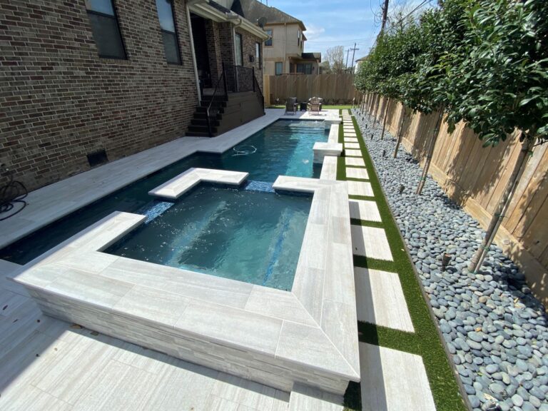 A pool with two pools and a grassy area.