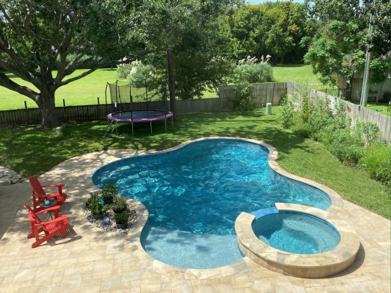 A pool with a diving board and a trampoline.